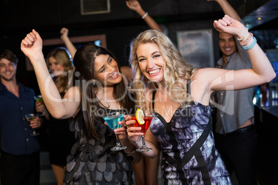 Portrait of friends having a drink and dancing