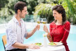 Cheerful couple toasting white wine