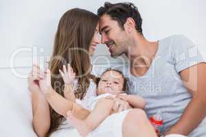 Couple enjoying with baby on bed