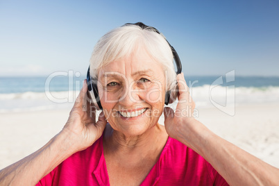 Senior woman listening music with headphone