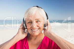 Senior woman listening music with headphone