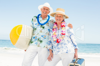 Senior couple holding surfboard