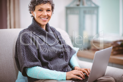 Portrait of happy mature woman using laptop