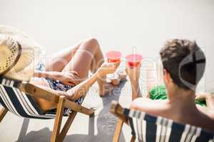 Couple sitting on armchair with cocktail drink