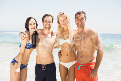 Portrait of happy friends standing together on the beach