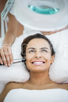 Close-up of happy young woman receiving facial massage