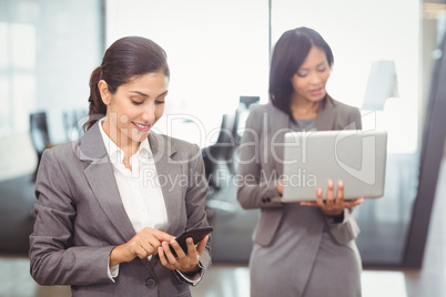 Businesswoman text messaging on mobile phone