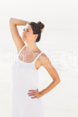 Beautiful woman in white outfit standing on the beach