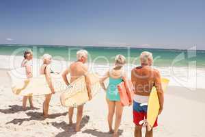 Senior friends holding surfboard