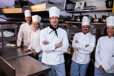 Happy chefs team standing together in commercial kitchen