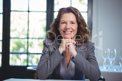 Smiling businesswoman leaning on a table