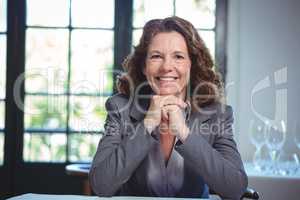 Smiling businesswoman leaning on a table