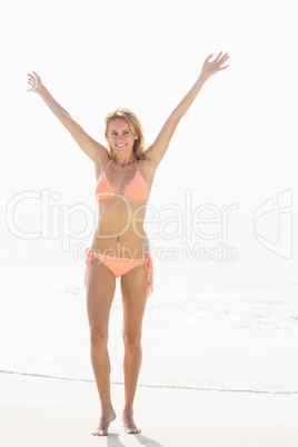 Portrait of excited woman in bikini standing on the beach