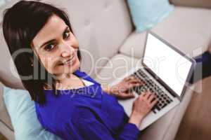 High angle portrait of smiling woman using laptop