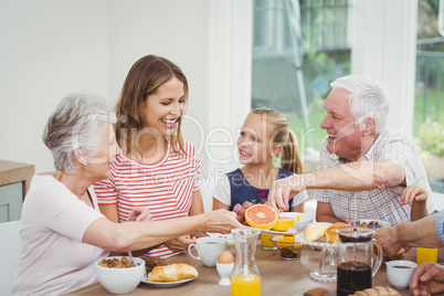 Multi-generation family eating fruits during breakfast