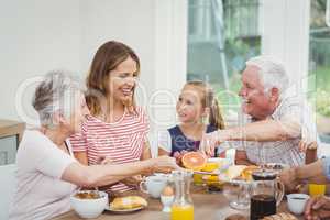 Multi-generation family eating fruits during breakfast