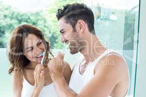 Close-up of young couple brushing teeth
