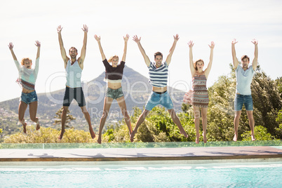 Group of friends jumping at poolside