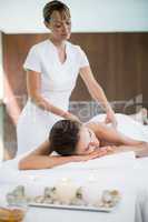 Masseur massaging back of woman