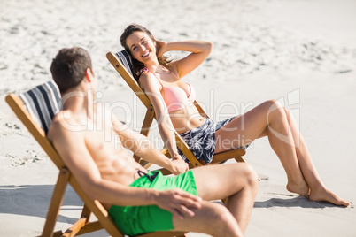 Young couple relaxing and talking on the beach