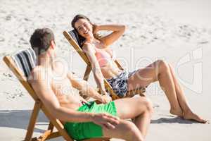 Young couple relaxing and talking on the beach