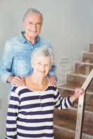 Portrait of cheerful senior couple standing on staircase