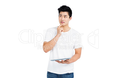 Thoughtful young man holding digital tablet