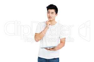 Thoughtful young man holding digital tablet