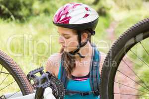 Woman fixing her bike