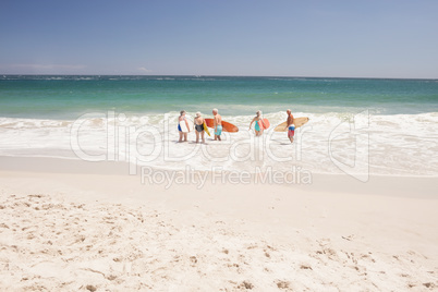 Senior friends holding surfboard