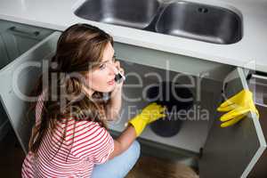 Woman talking on mobile phone while holding bucket