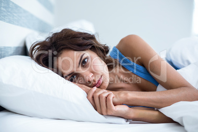 Sad woman lying on bed