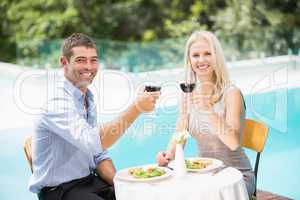 Portrait of smiling couple holding red wine