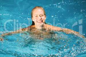 Portrait of beautiful woman swimming in swimming pool