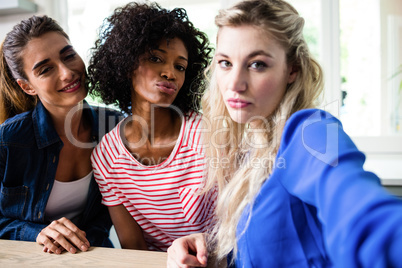 Portrait of beautiful young female friends puckering lips