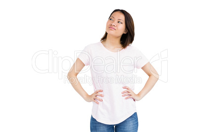 Thoughtful young woman standing with hands on hip