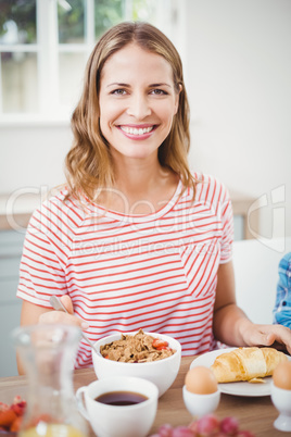 Happy woman doing breakfast at table