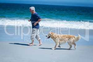 Mature man running next to his dog