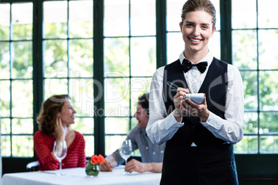 Portrait of beautiful waitress writing down an order