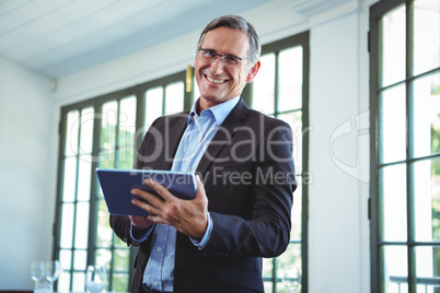 Smiling businessman using a tablet