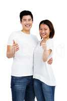 Young couple showing thumbs up sign