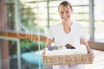 Portrait of smiling masseur holding beauty therapy items