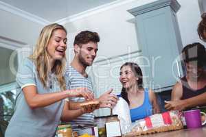 Smiling woman preparing sandwich