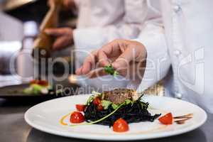 Chef garnishing meal on counter