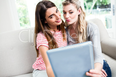 Female friends taking selfie with digital tablet