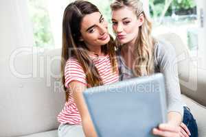 Female friends taking selfie with digital tablet