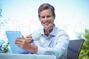 Businessman using tablet with coffee