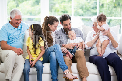 Smiling family with grandparents sitting on sofa