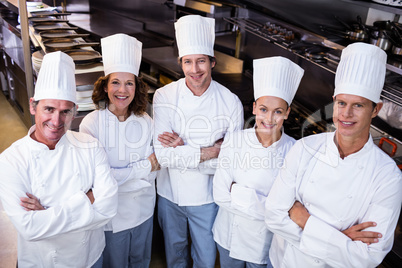 Happy chefs team standing together in commercial kitchen