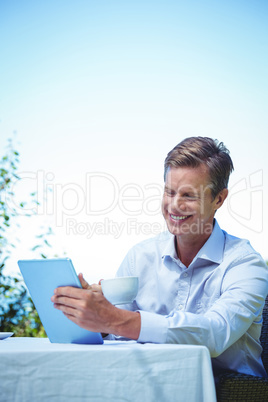 Businessman using tablet with coffee